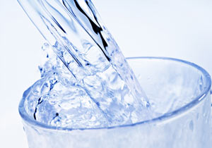 Wasser wird in eine Glas geschüttet.