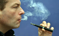 Mann inhaliert Rauch von E-Zigarette.