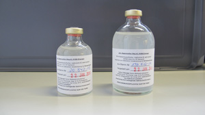Zwei unterschiedlich große Glasfläschchen mit klarer Flüssigkeit und der Aufschrift Bestandsspezifischer Impfstoff