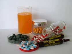 Glas mit Saft und Tabletten als Nahrungsergänzungsmittel 