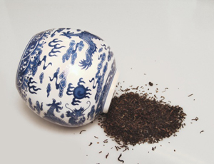 getrockneter Tee rieselt aus einer chinesischen Porzellandose