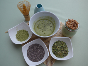 Die Abbildung  zeigt oben Match-Pulver und angerührtes Matcha, darunter links Chia-Samen und rechts Moringa-Blätter