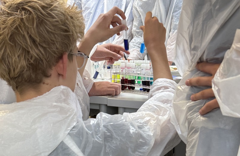 Junge mit bunten Reagenzgläschen. 