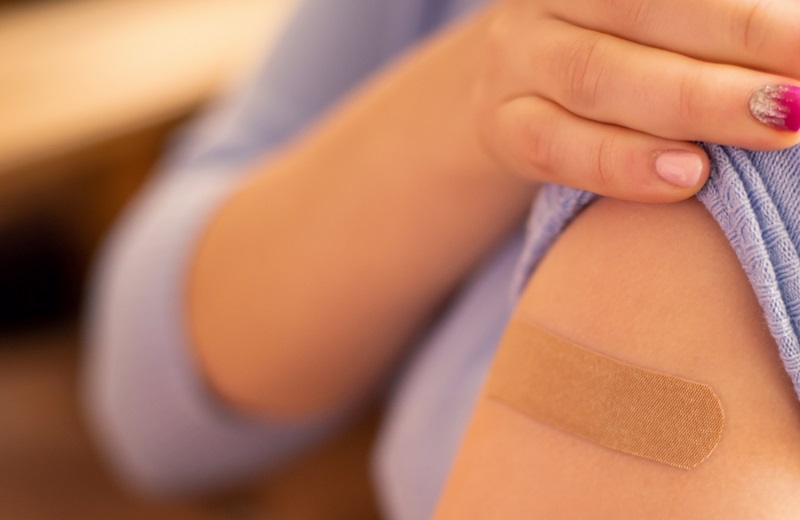 Arm eines Mädchens mit Impfpflaster.