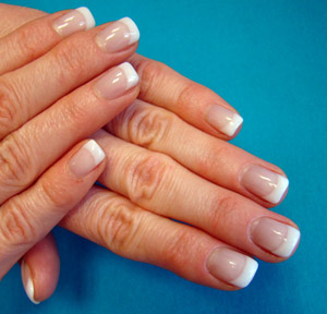 Zwei aufeinanderliegende Hände, deren Fingernägel im French-Nail-Style modelliert wurden.