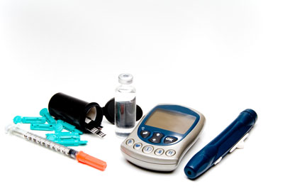 farbige Fotographie von Blutzuckergerät, PEN, Ampulle, schwarzer Becher mit Teststäbchen, Einmalspritze